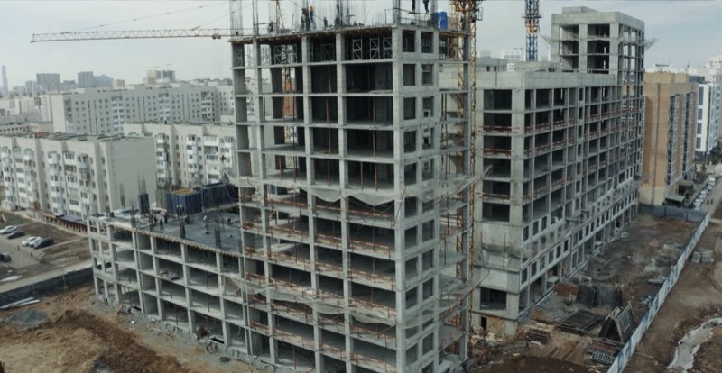 Монолитный железобетонный каркас многоэтажного здания с башенными кранами